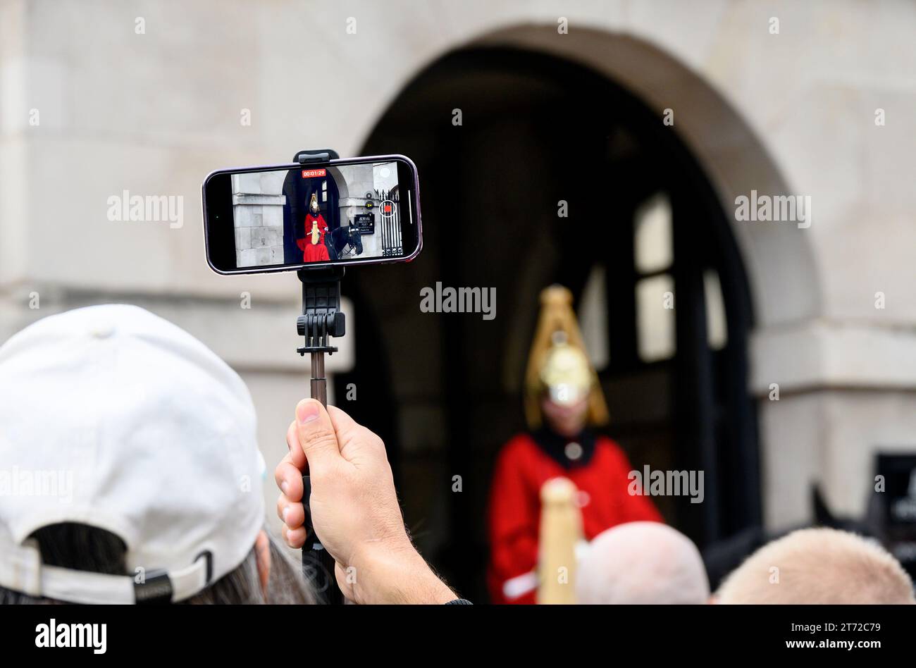 London, Großbritannien. Ein Tourist filmt ein Mitglied der Household Cavalry in Horse Guards auf seinem Handy Stockfoto