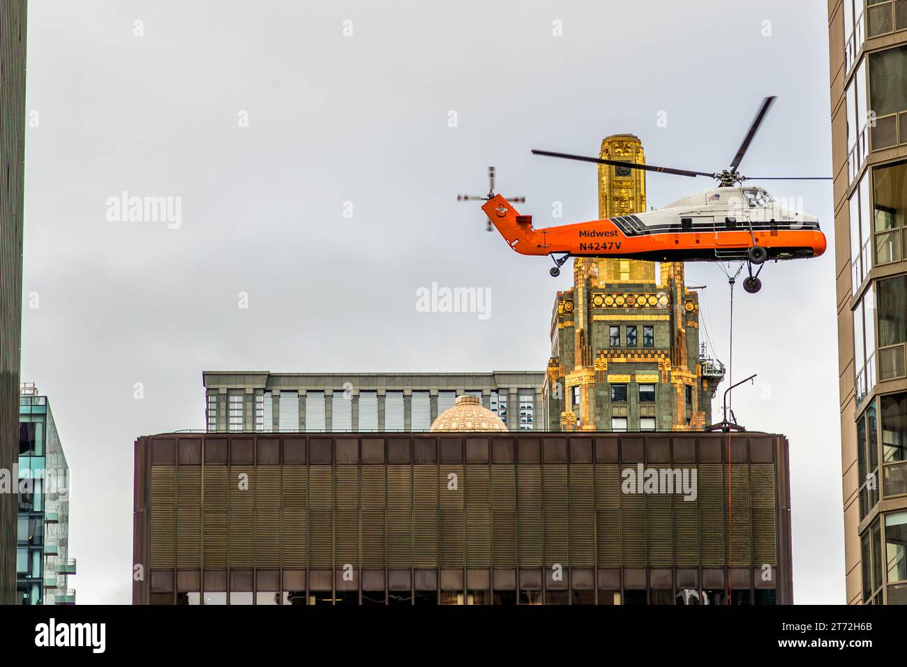 Hubschraubereinsatz in den engen Hochhauskorridoren von Chicago, USA. Die goldene Turmspitze des Carbide- und Carbon-Turms ist im Hintergrund zu sehen Stockfoto