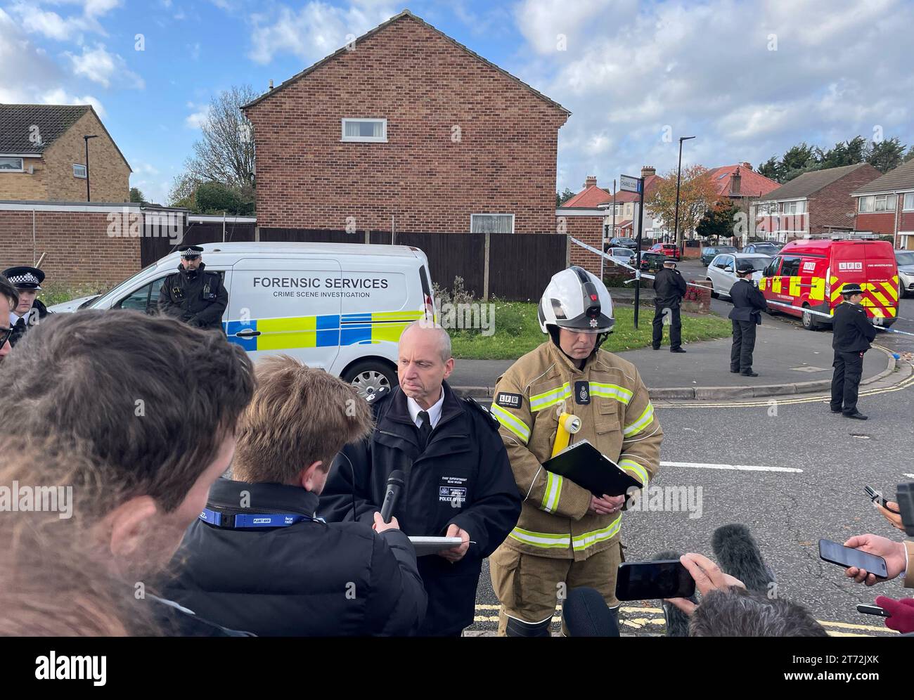 Sean Wilson, Chief Superintendent der Metropolitan Police, sprach mit Jonathan Smith von der Londoner Feuerbrigade vor den Medien am Tatort nach einem Hausbrand in Channel Close, Hounslow, bei dem fünf Menschen ums Leben kamen. Zehn Feuerwehrfahrzeuge und etwa 70 Feuerwehrleute wurden am Sonntag um 22:26 Uhr zur Flamme gerufen, sagte die Londoner Feuerwehr. Bilddatum: Montag, 13. November 2023. Stockfoto