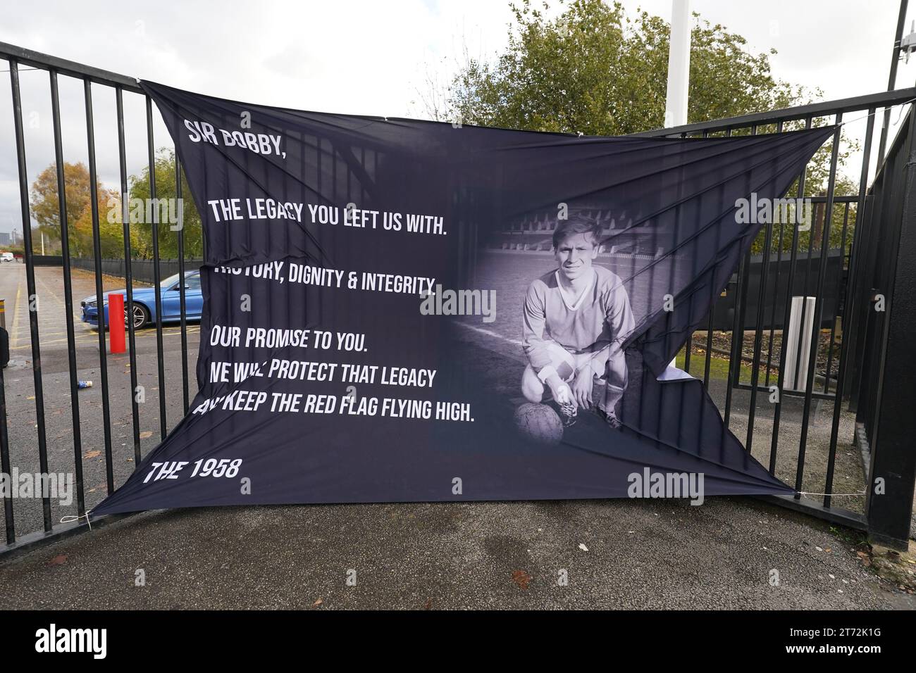 Ein Tribut-Banner an einem Tor vor Old Trafford in Manchester vor der Trauerprozession für den britischen Sir Bobby Charlton, der im Oktober im Alter von 86 Jahren starb. Charlton erzielte 249 Tore für Manchester United und half ihnen, drei Meistertitel, einen FA Cup und den Europapokal 1968 zu gewinnen. Auf internationaler Ebene war er Teil der englischen Mannschaft, die 1966 die Weltmeisterschaft gewann. Bilddatum: Montag, 13. November 2023. Stockfoto