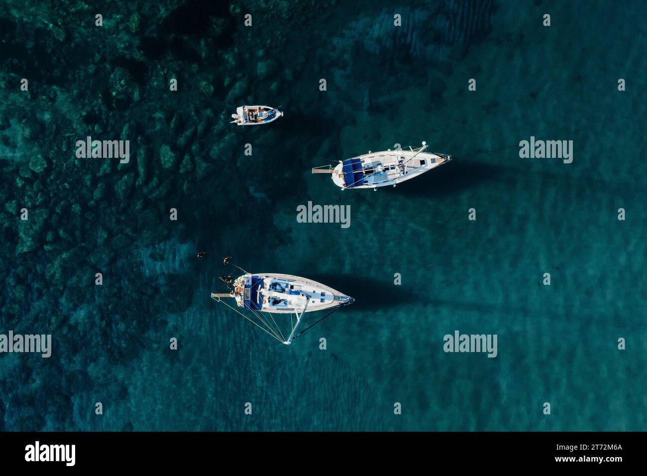 Segelyachten im blauen Meer, Blick von oben. Segelyacht auf dunklem Hintergrund, Luftsicht. Stockfoto
