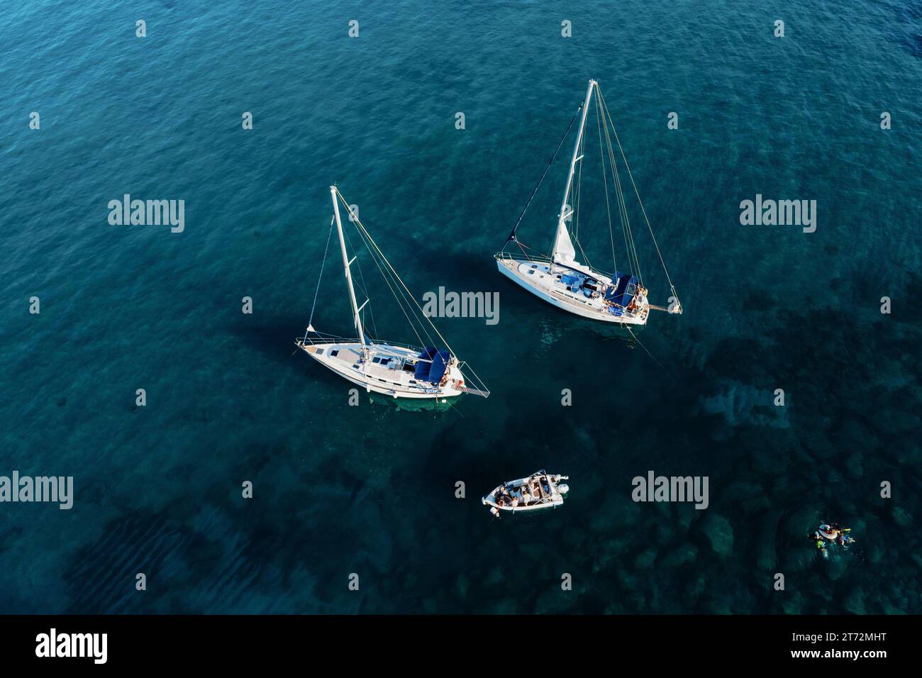 Segelyachten im blauen Meer, Blick von oben. Segelyacht auf dunklem Hintergrund, Luftsicht. Stockfoto