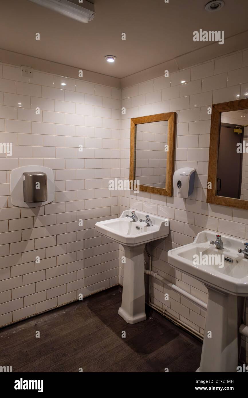 Öffentliches Bad, Toilette mit zwei weißen Emailwaschbecken Stockfoto