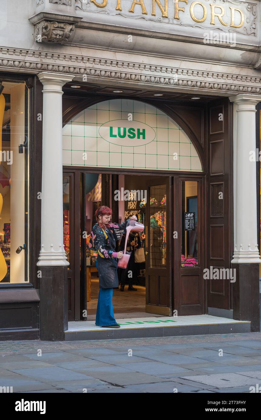 Üppiger Kosmetikladen in Covent Garden. Eine junge Frau (Angestellte?) Zeigt ein rosafarbenes flüssiges Produkt, das von einer Kanne in eine andere fließt. London England Großbritannien Stockfoto