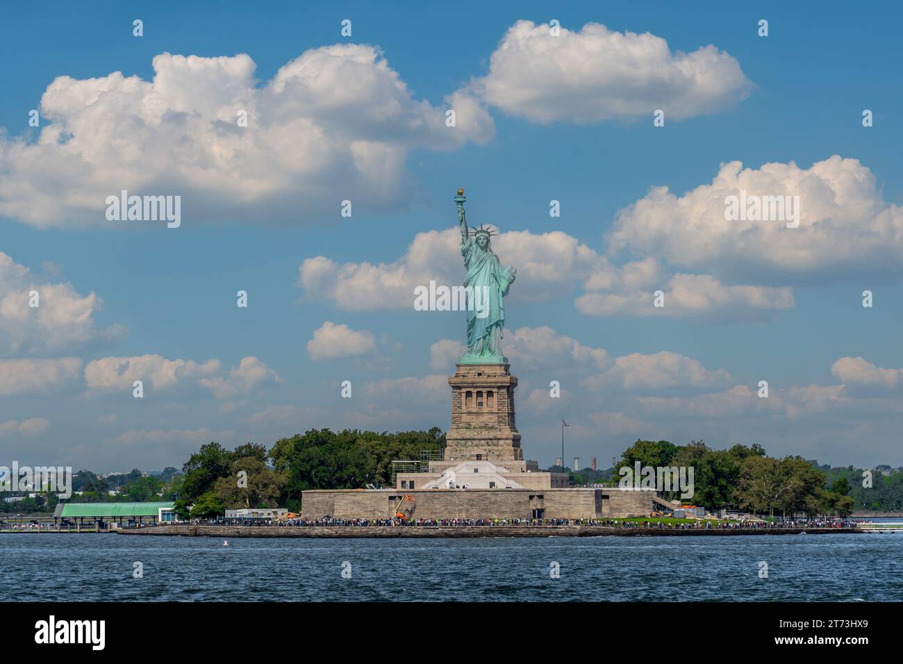 FREIHEITSSTATUE, NEW YORK, USA - 16. SEPTEMBER 2023 Ein landschaftliches Panorama der Freiheitsstatue und Liberty Island voller Touristen an einem sonnigen Tag Stockfoto