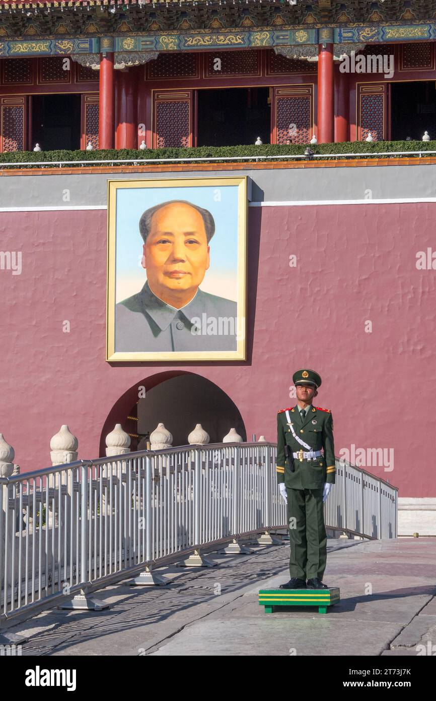 Chinesischer Soldat auf dem Tian'an Men Square, Peking (Peking) China. Hinter ihm hängt das Porträt des ehemaligen chinesischen Führers Mao Zedong. Stockfoto