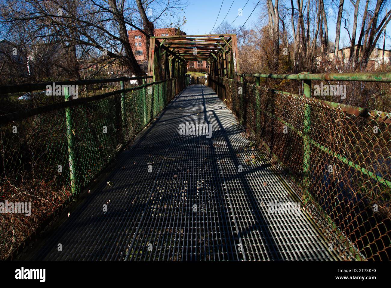 Rostgrüne Fußbrücke über den Fluss. Stockfoto