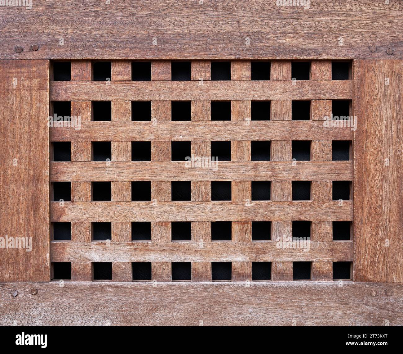 Handwerkskunst aus braunem Holz - altes Gitter mit quadratischen Löchern Stockfoto