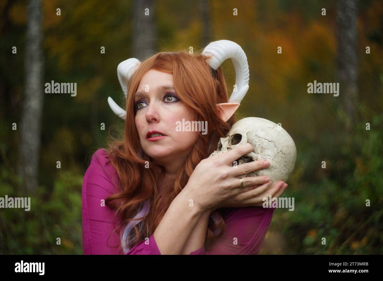 Porträt eines sehnsüchtigen weiblichen Tieflings mit Skull Cosplay Stockfoto