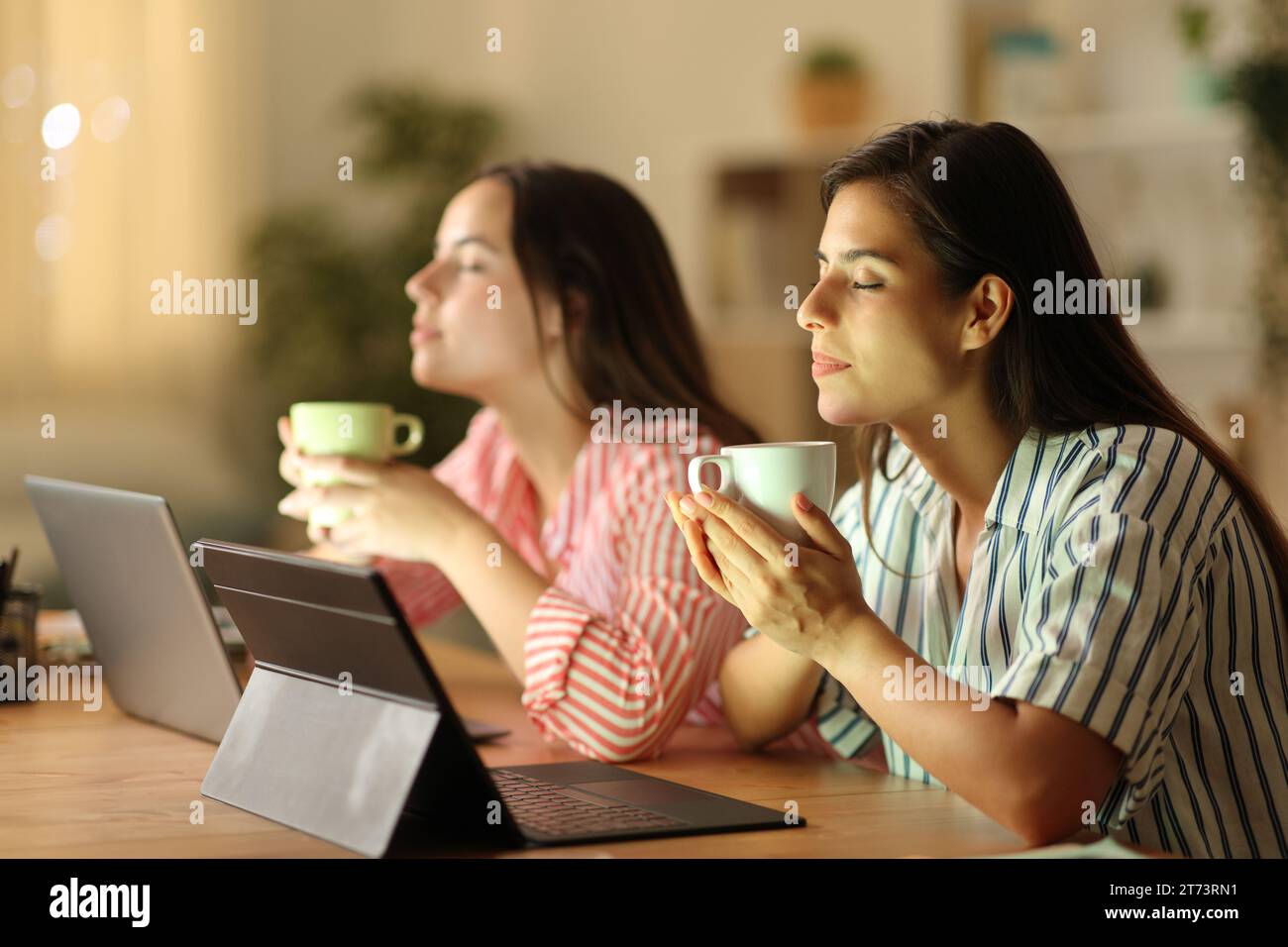 Zwei Tele-Mitarbeiter entspannen sich bei einem Kaffee in der Nacht zu Hause Stockfoto