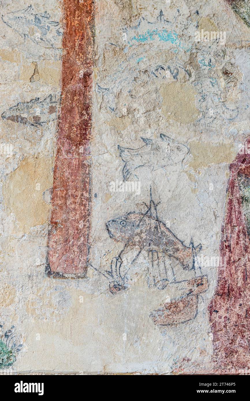 Details eines Schiffes und Fischen in einem Wandgemälde des hl. Christophorus aus dem 14. Jahrhundert in der Kirche St. Maria Magdalena im Dorf Cotswold Stockfoto