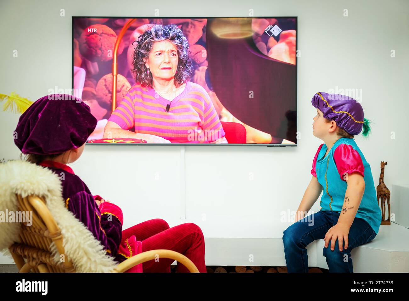 ILLUSTRATION - Kinder sehen die Sinterklaas-Nachrichten im Fernsehen im Wohnzimmer, die wieder angefangen haben. ANP JEFFREY GROENEWEG niederlande Out - belgien Out Stockfoto