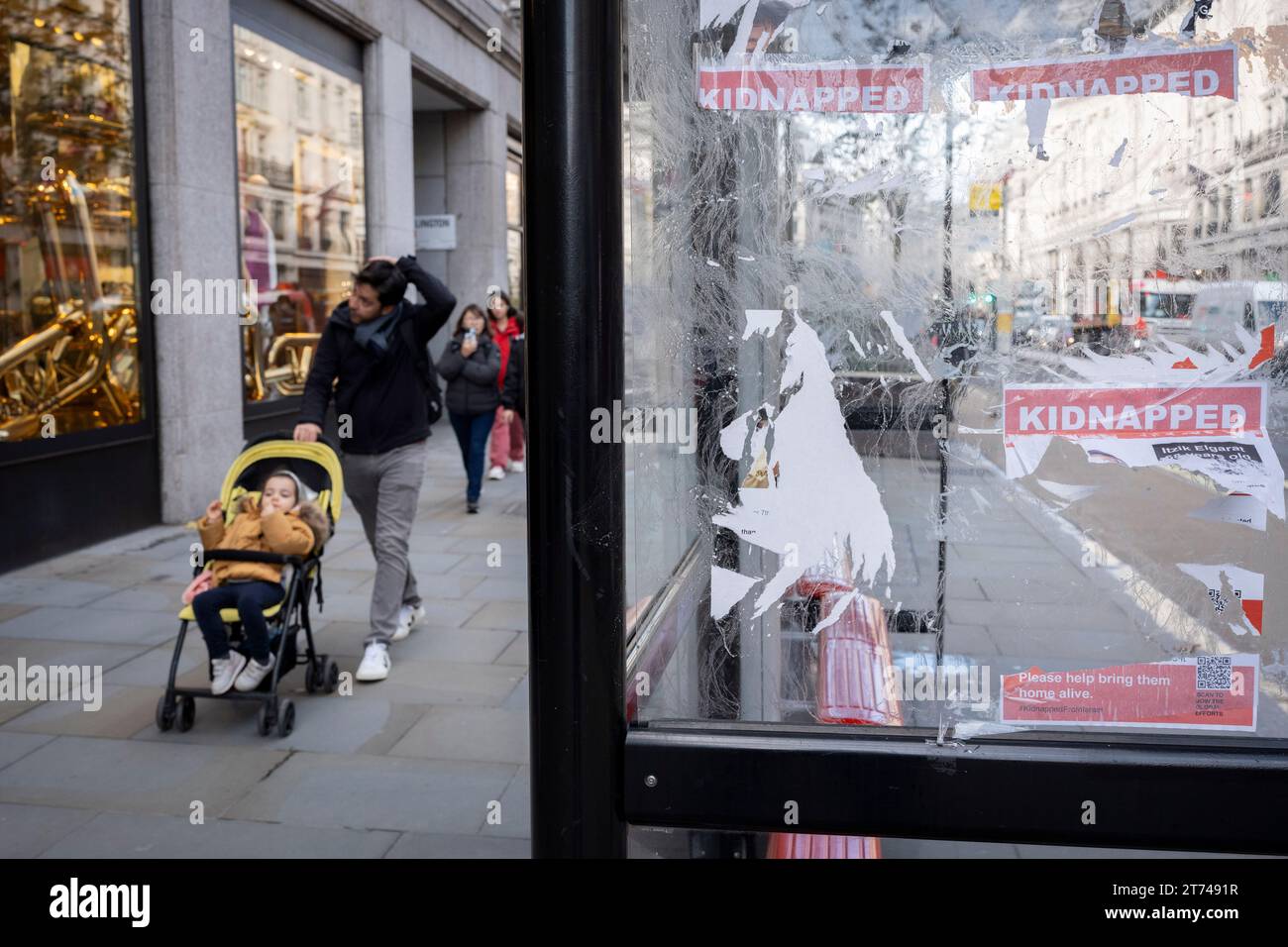 Flyer und Plakate mit den Namen und Gesichtern israelischer Geiseln, die von der Hamas ergriffen wurden, werden am 13. November 2023 an einer Bushaltestelle in London, England, beschädigt, gerissen und verunreinigt. Stockfoto