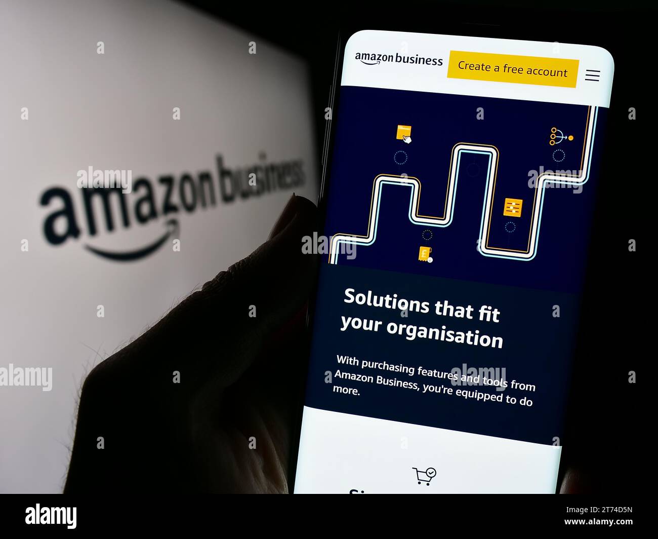 Person, die ein Mobiltelefon hält und die Webseite des US-amerikanischen E-Commerce-Plattformunternehmens Amazon Business vor dem Logo zeigt. Konzentrieren Sie sich auf die Mitte des Telefondisplays. Stockfoto