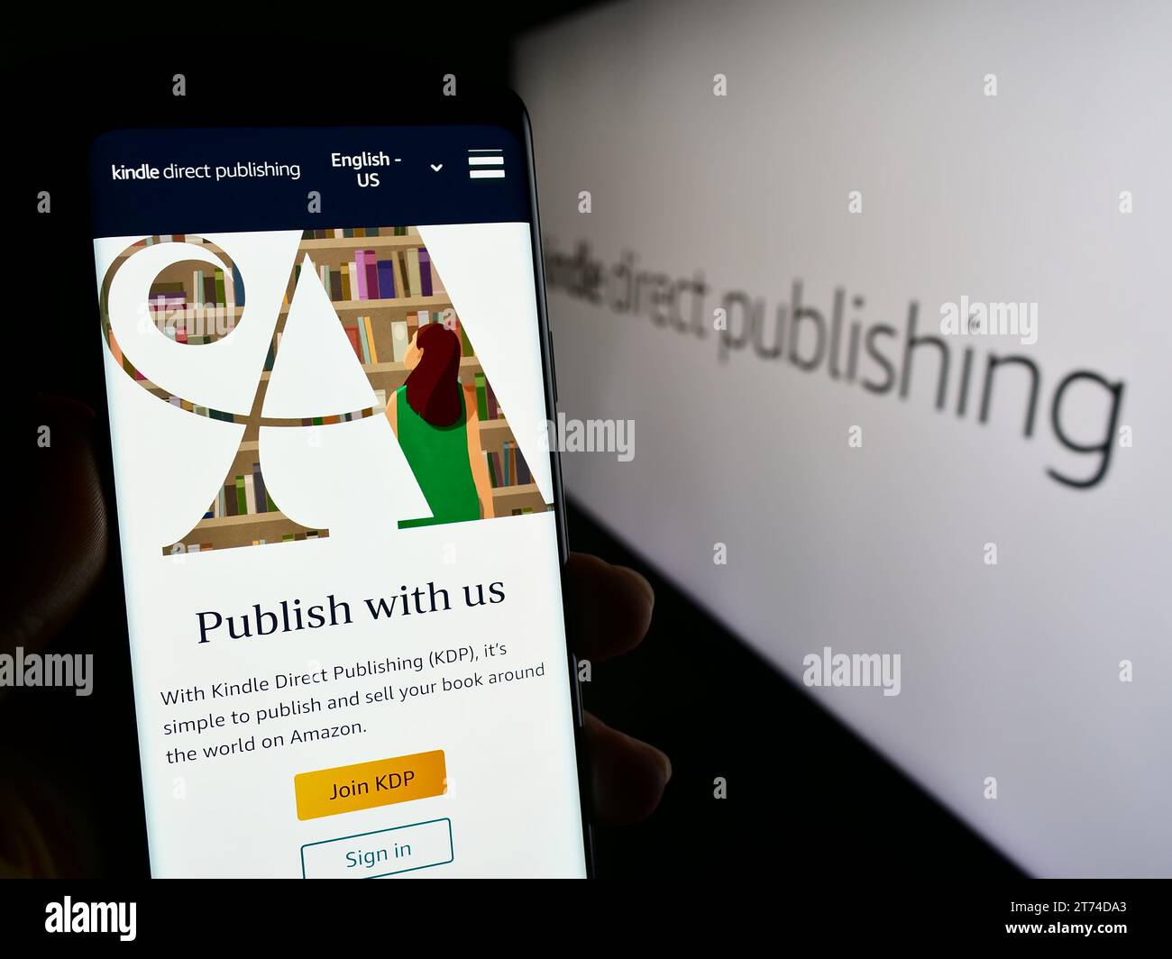 Person mit Smartphone und Website der Amazon E-Book-Plattform Kindle Direct Publishing (KDP) mit Logo. Konzentrieren Sie sich auf die Mitte des Telefondisplays. Stockfoto