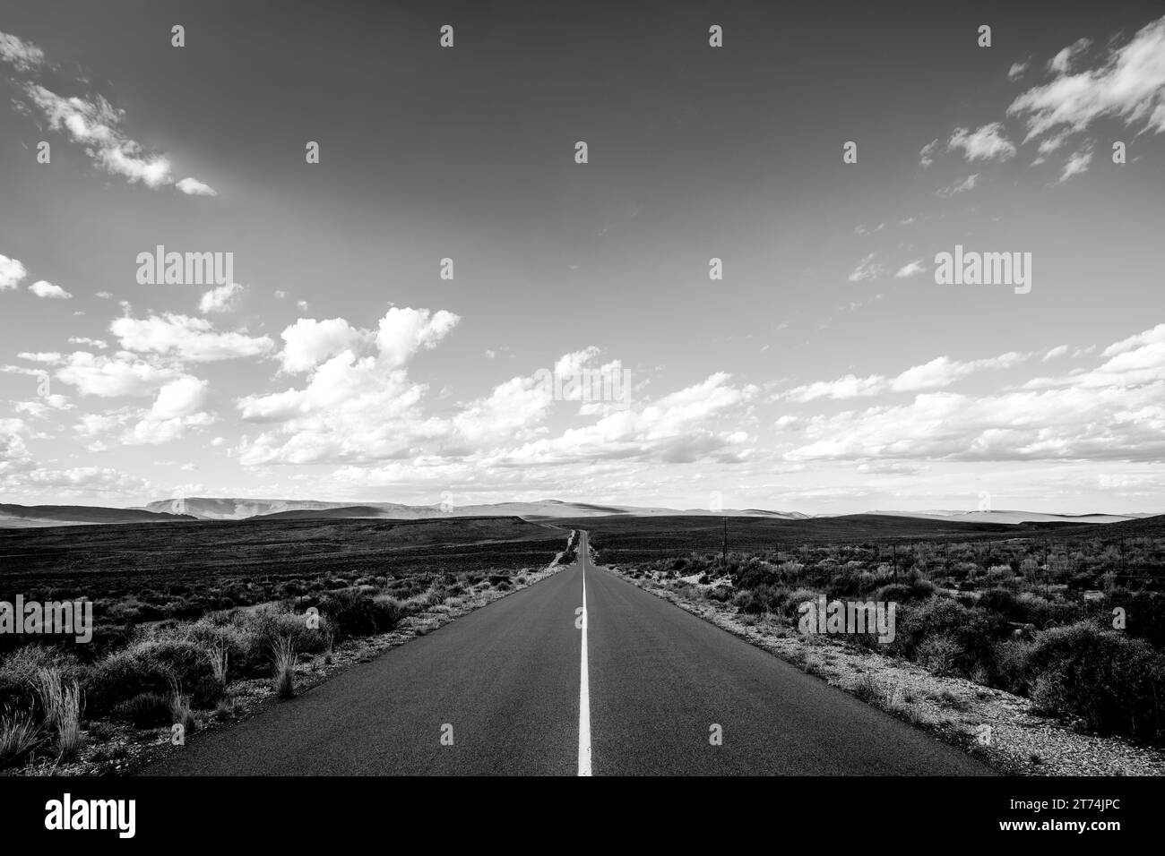Ein Blick aus der Vogelperspektive auf eine gewundene Straße, die durch eine bergige Landschaft führt Stockfoto
