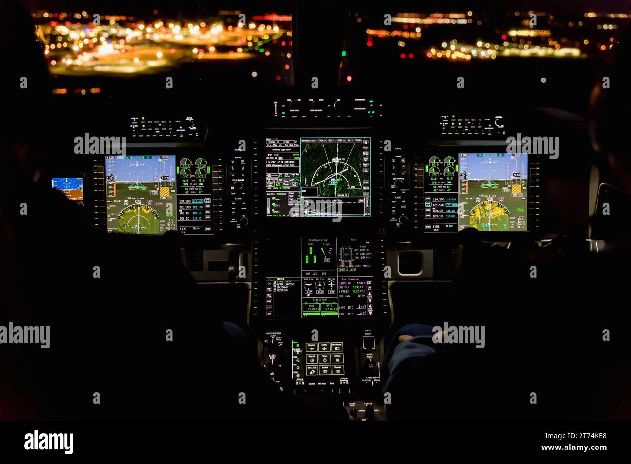 Blick aus dem Cockpit eines modernen Flugzeugs, das nachts auf einem beleuchteten Flughafen landet. Beleuchtetes Cockpit-Armaturenbrett aus Glas bei der Landung am Flughafen Stockfoto