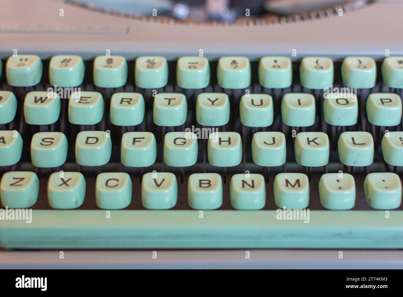 Nahaufnahme der grünen Tasten aus Meeresschaum mit schwarzem Schriftzug auf einer Vintage-Schreibmaschine. Stockfoto