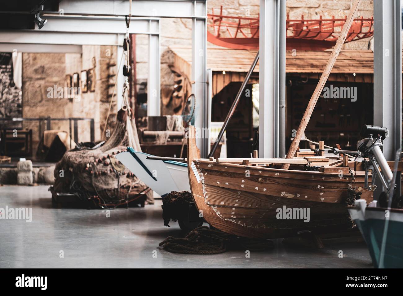 In einem Museumslager wird ein historisches Holzboot ausgestellt, das seine rustikale Schönheit und seine primitive Bauweise zeigt Stockfoto