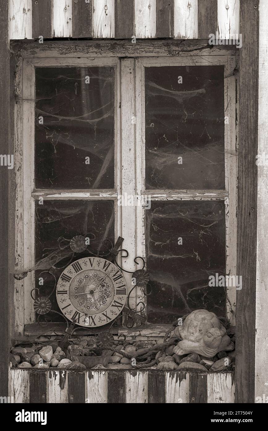 Fenster eines alten Bauernhauses mit Spinnweben und alter Küchenuhr, Bayern, Deutschland Stockfoto