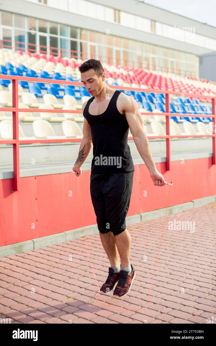 Muskulöser männlicher Athlet überspringt das Stadion vor der Arena Stockfoto