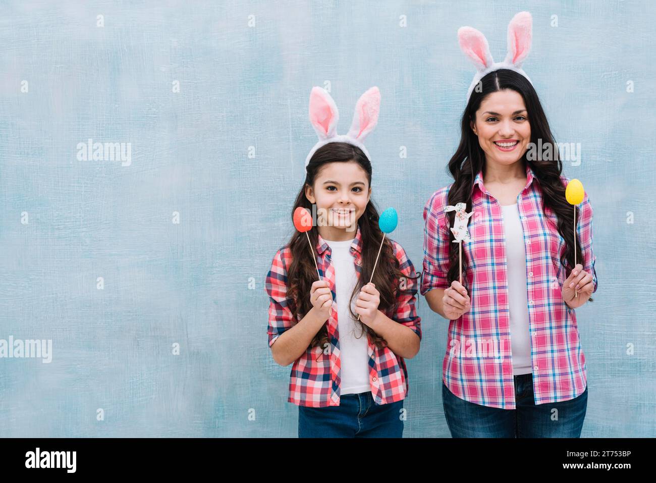 Mutter-Tochter trägt Hasenohren und hält ostereier Hasen-Requisiten Stockfoto