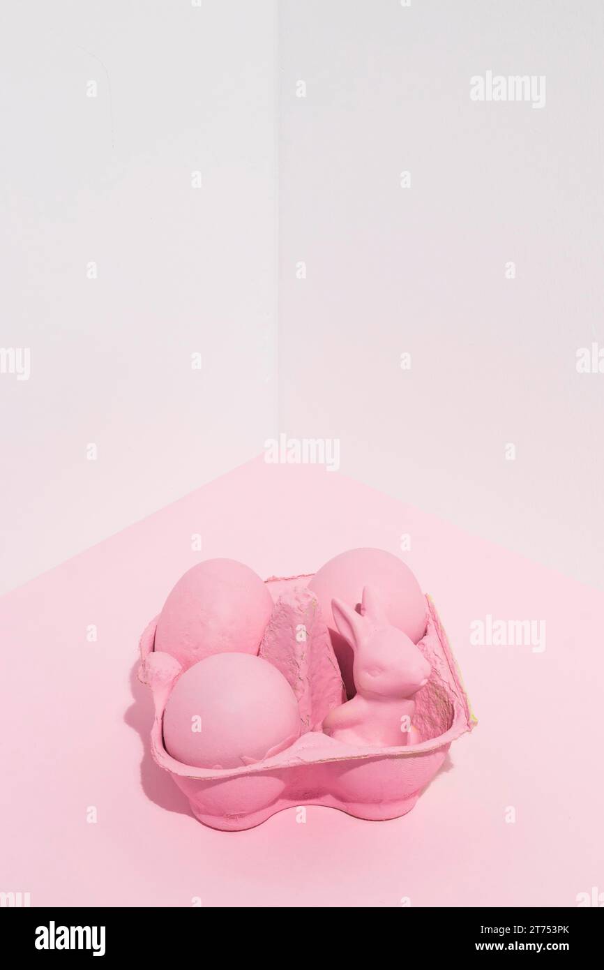Rosafarbene ostereier mit kleinem Kaninchenständer Stockfoto