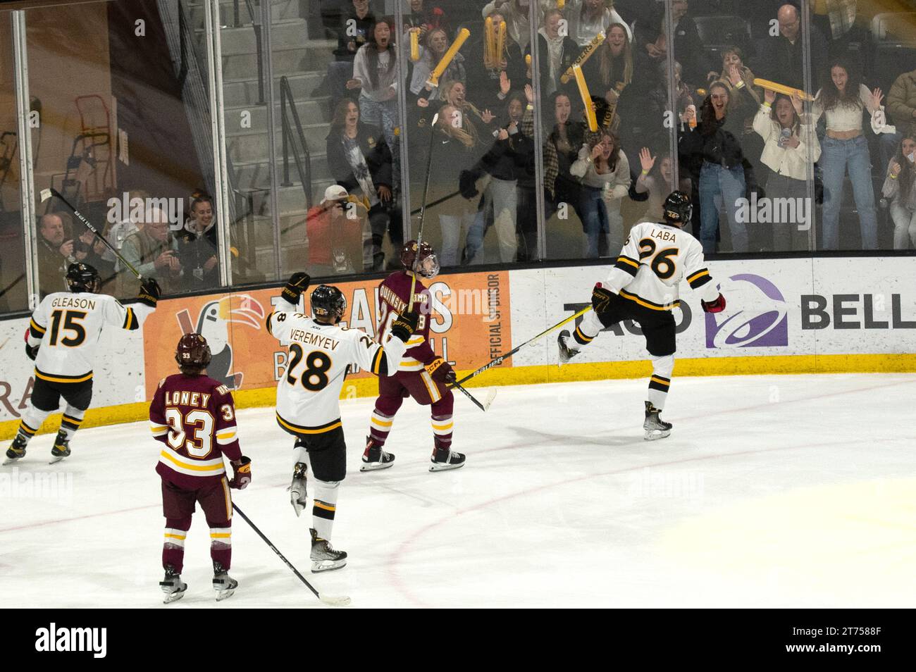 Noah LABA vom Colorado College (26 in weiß) feiert das Tor während eines NCHC College-Hockeyspiels, während die Fans jubeln. Stockfoto