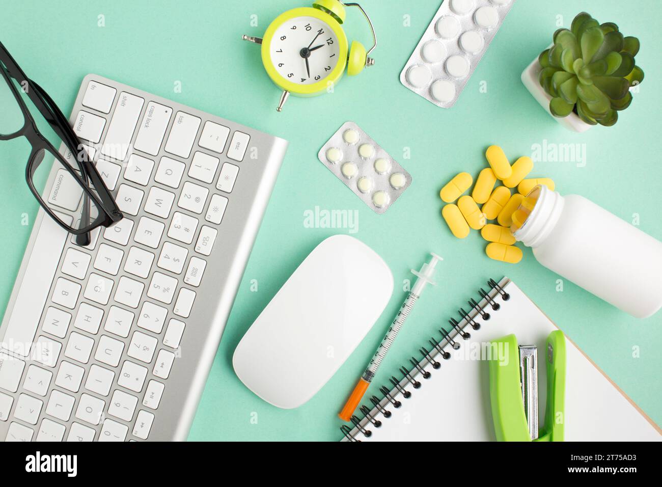Medikamente Schreibwaren drahtlose Geräte Wecker grüner Hintergrund Stockfoto