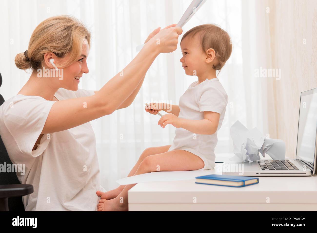 Mid-Shot-Mutter spielt Guck mit Baby Stockfoto