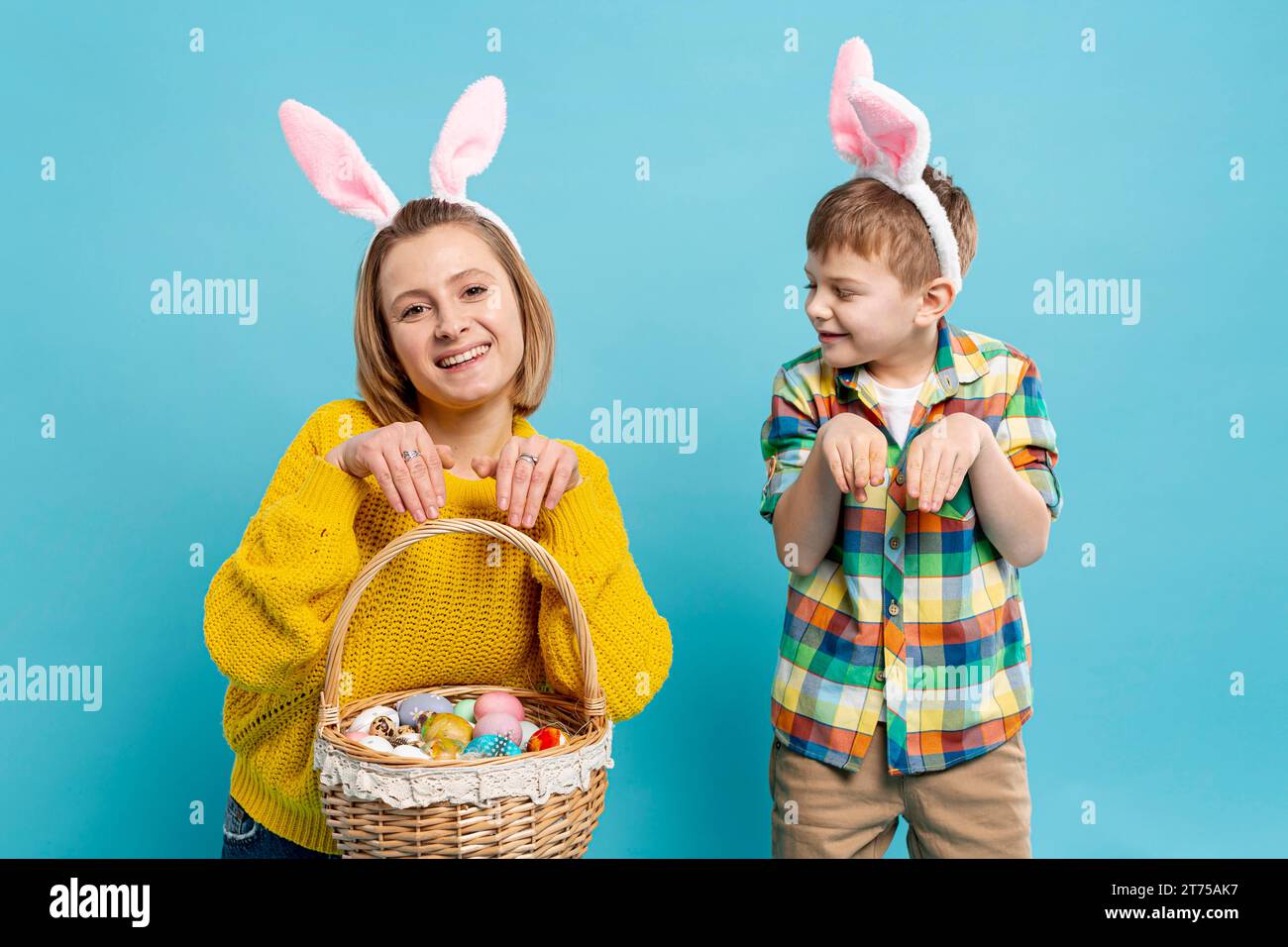 Muttersohn imitiert die Position des Kaninchens Stockfoto