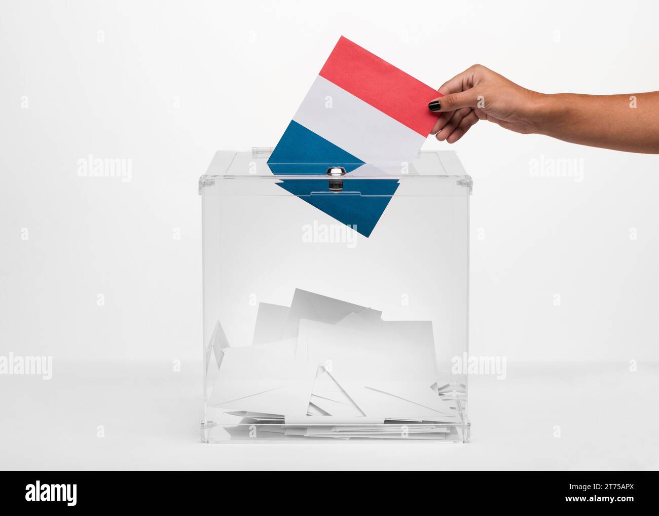 Person, die die französische Flaggenkarte in die Wahlurne legt Stockfoto