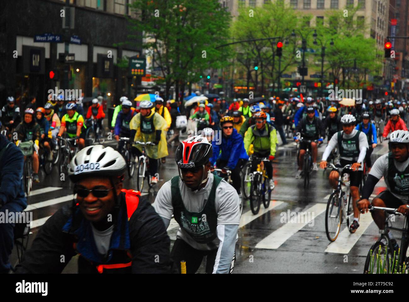 Eine große Gruppe von Fahrradfahrern geht während der New York Five Borough Bike Tour im Regen durch die Straßen von Manhattan Stockfoto