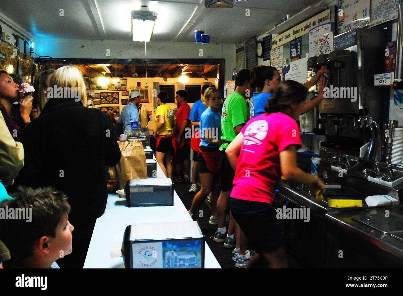Teenager, die einen Sommerjob haben, warten in einem belebten Eiscafé auf Kunden Stockfoto