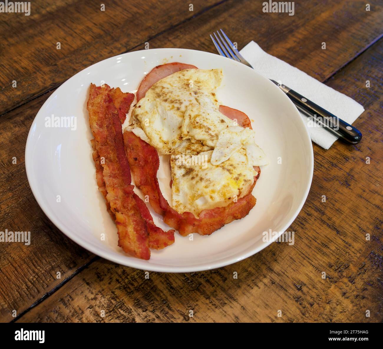 Frühstück mit Speck und Spiegeleiern ein traditionelles amerikanisches Frühstück auf einem Tisch. Stockfoto