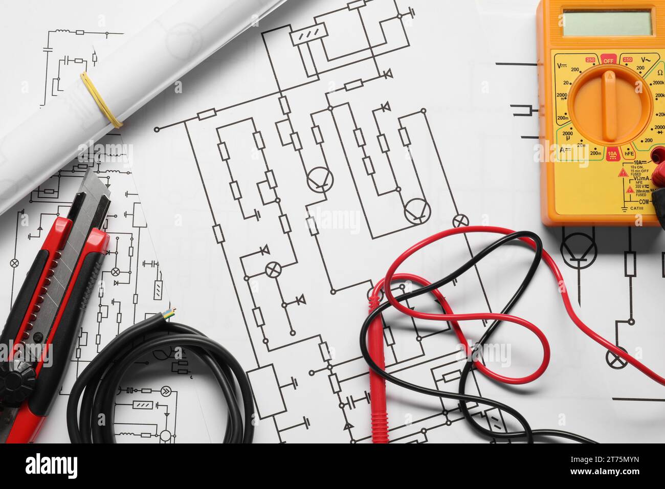 Drähte und Digitalmultimeter auf Schaltplänen, Draufsicht Stockfoto