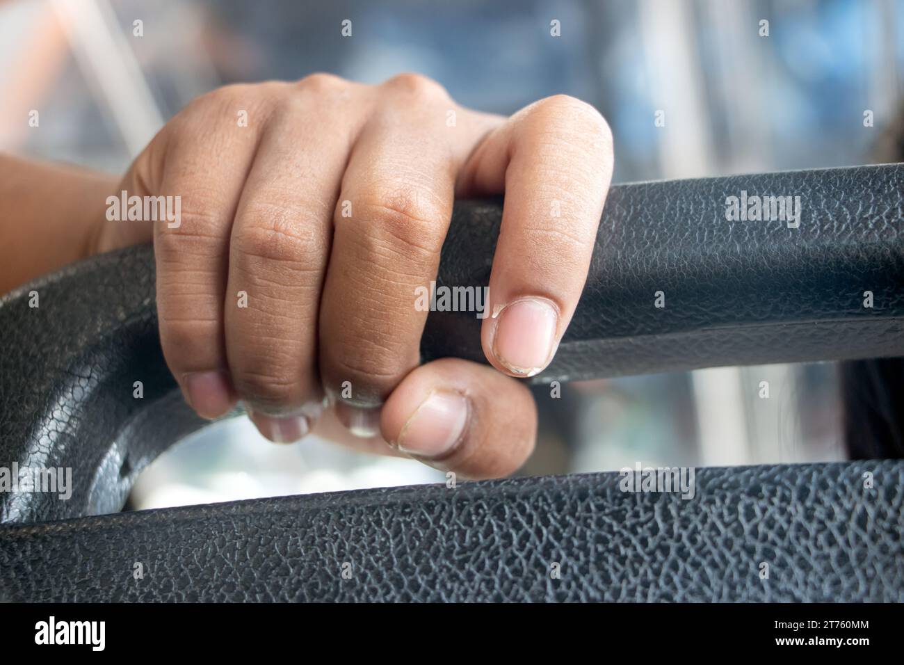 Die Hand des Passagiers hält sich an der Fahrt in einem alten Stadtbus mit öffentlichen Verkehrsmitteln fest Stockfoto