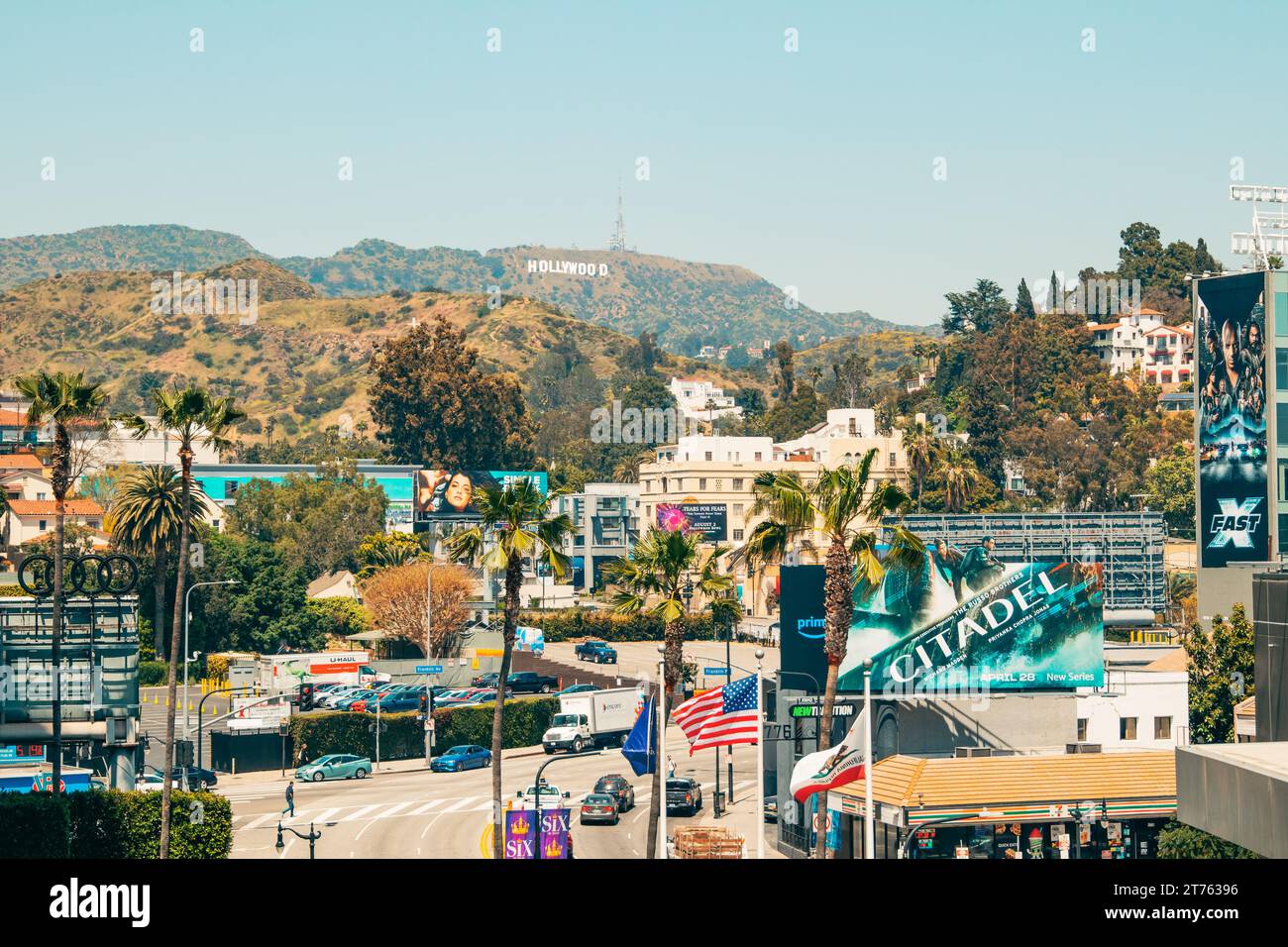 Los Angeles, Kalifornien, USA - 26. April 2023. Hollywood-Hügel und Hollywood-Schild, bunte Plakate, Palmen, Verkehr, Touristen Stockfoto