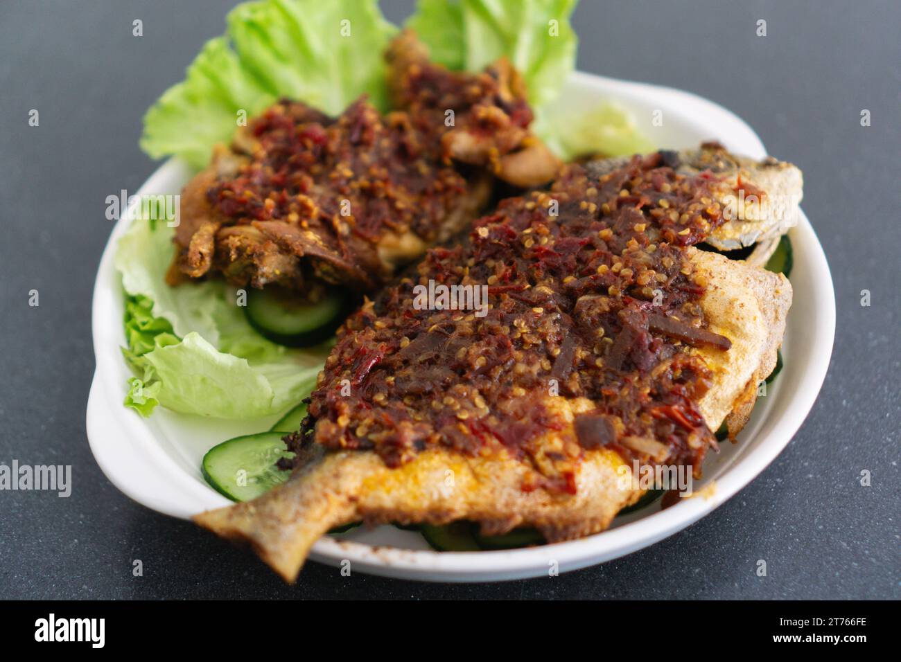 Ikan Goreng Masak Sambal, gebratener Fisch mit Chilipaste. Traditionelles indonesisches und malaysisches Gericht Stockfoto