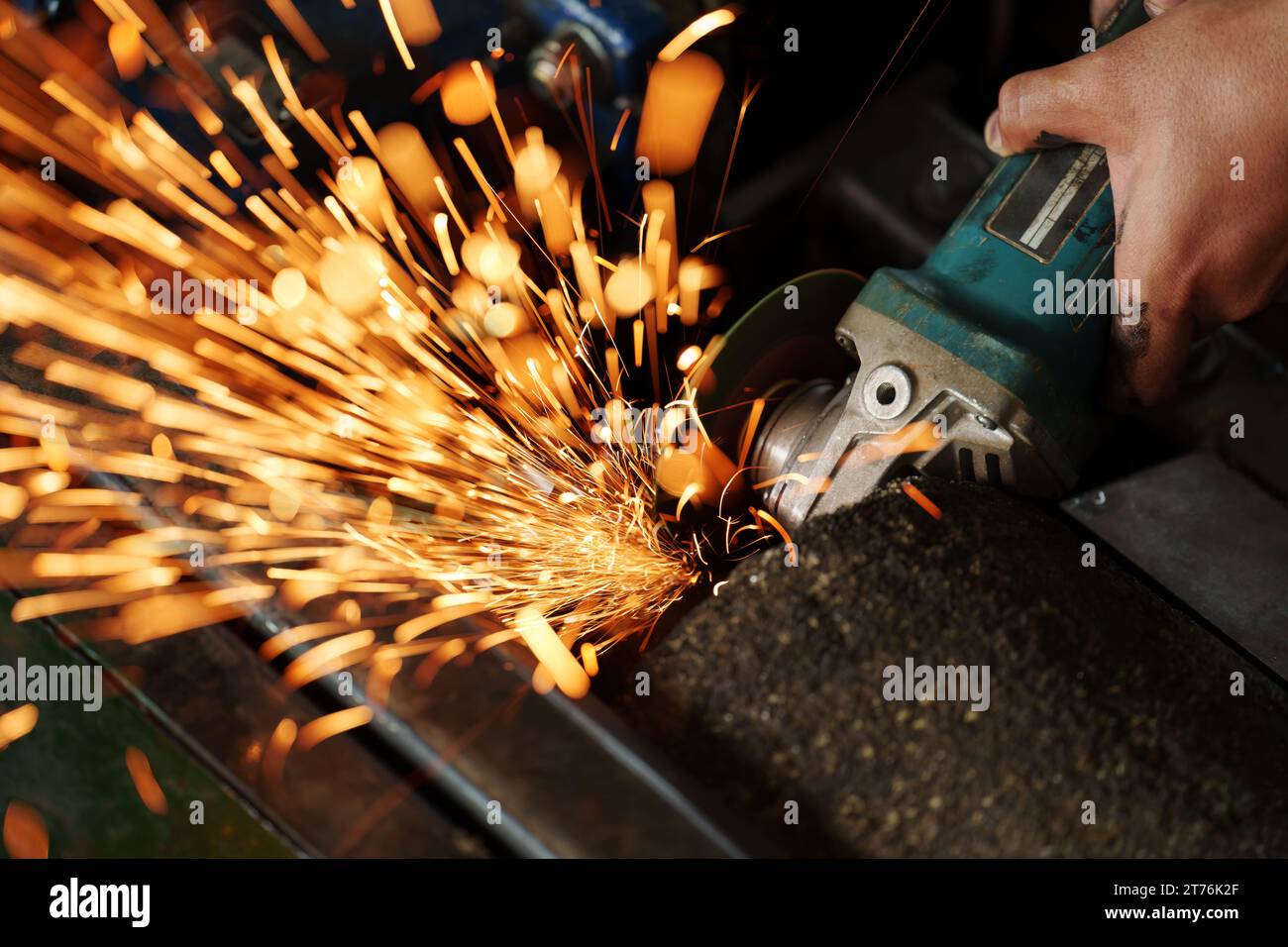 Arbeiter mit Winkelschleifmaschine zum Schleifen des Metalls Stockfoto