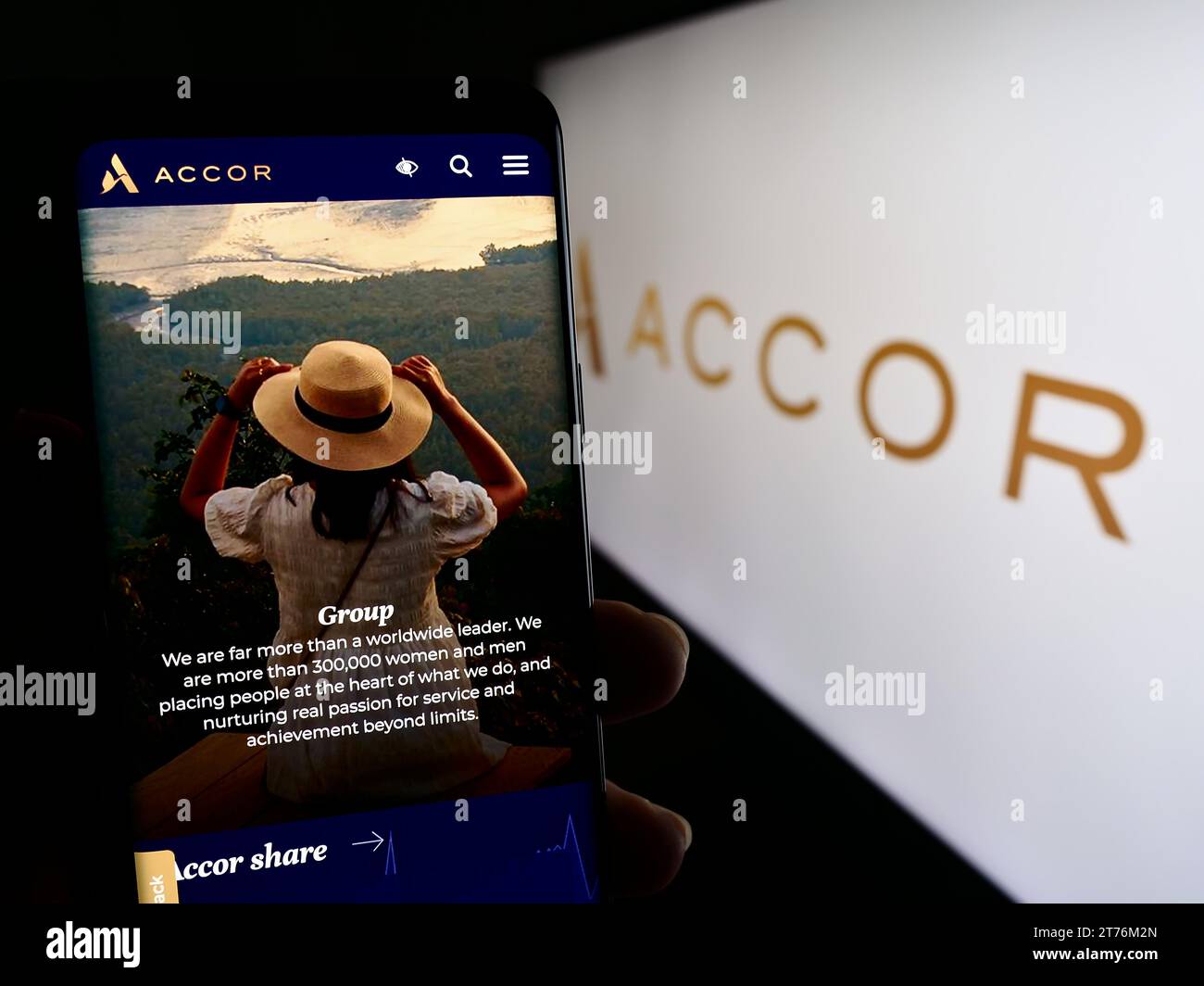 Person mit Mobiltelefon und Webseite des französischen Hotelunternehmens Accor S.A. vor dem Firmenlogo. Konzentrieren Sie sich auf die Mitte des Telefondisplays. Stockfoto
