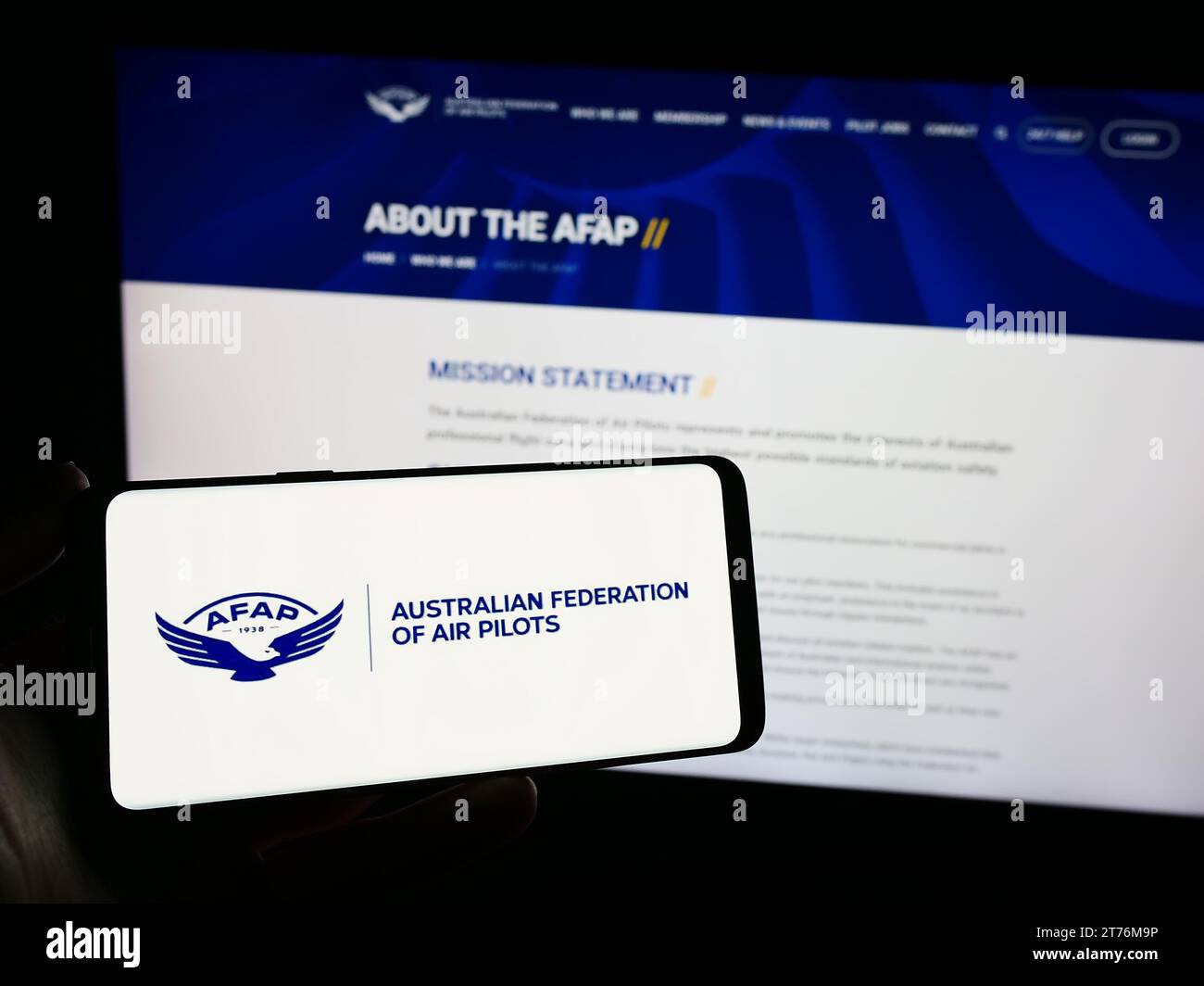 Person mit Smartphone und Logo des Verbands Australian Federation of Air Pilots (AFAP) vor der Website. Schwerpunkt auf dem Display des Telefons. Stockfoto