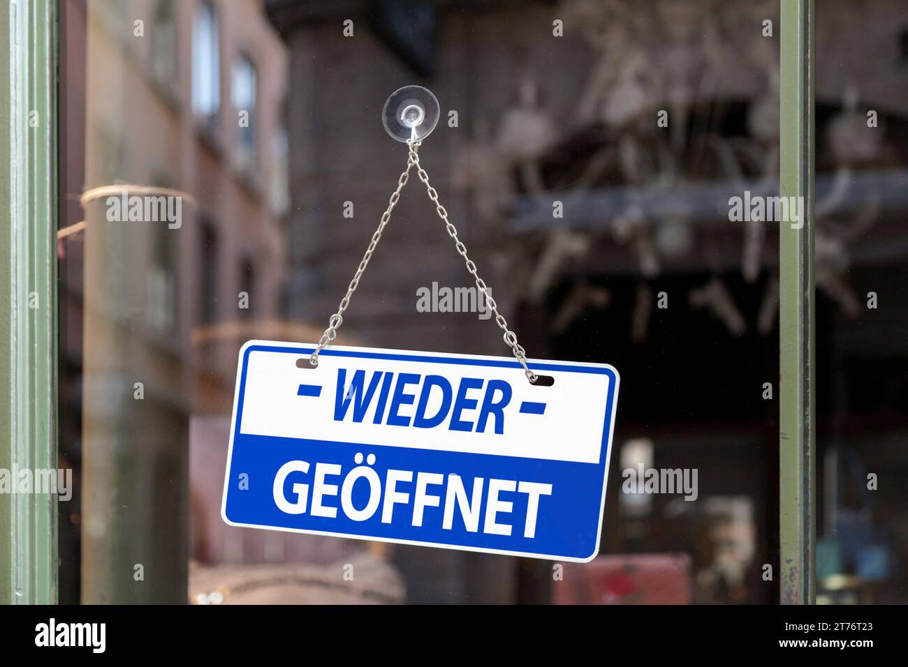 Nahaufnahme auf einem blauen Schild in einem Fenster, das innen geschrieben ist 'wieder geöffnet'. Stockfoto