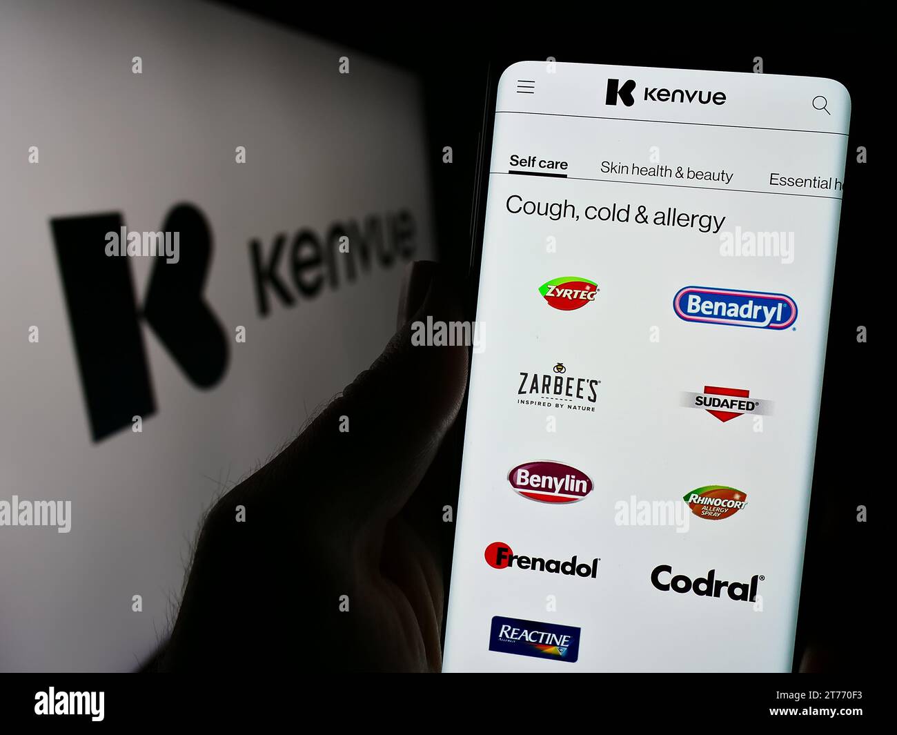 Person, die ein Mobiltelefon hält, mit der Webseite des US-amerikanischen Unternehmens für Gesundheitsprodukte Kenvue Inc. Vor dem Logo. Konzentrieren Sie sich auf die Mitte des Telefondisplays. Stockfoto