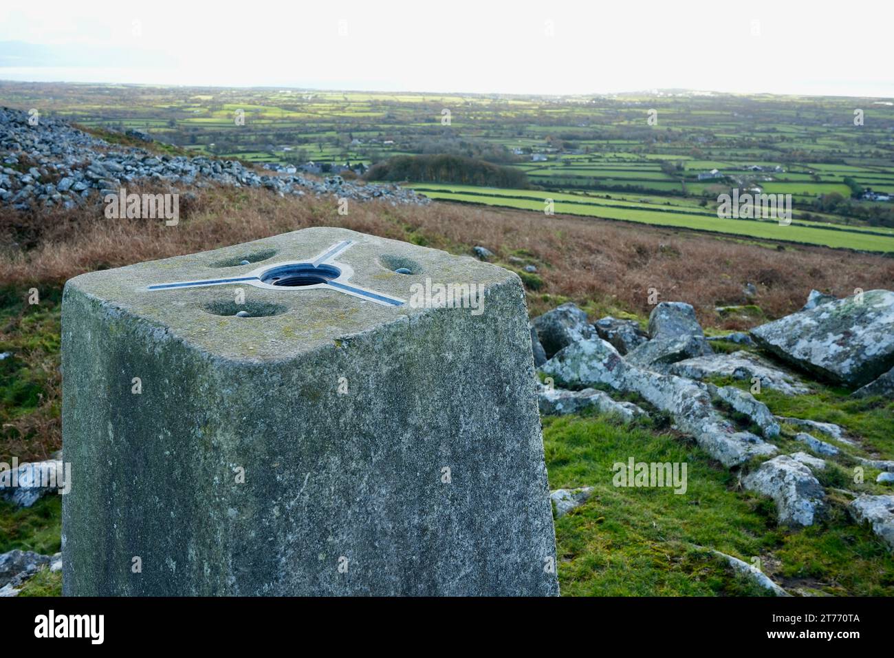 Trig Point Marker mit Blick auf die Landschaft von Nordwales und die Ceredigion Bay. Llangybi, Pwllheli, Wales, Großbritannien. November 2023. Stockfoto