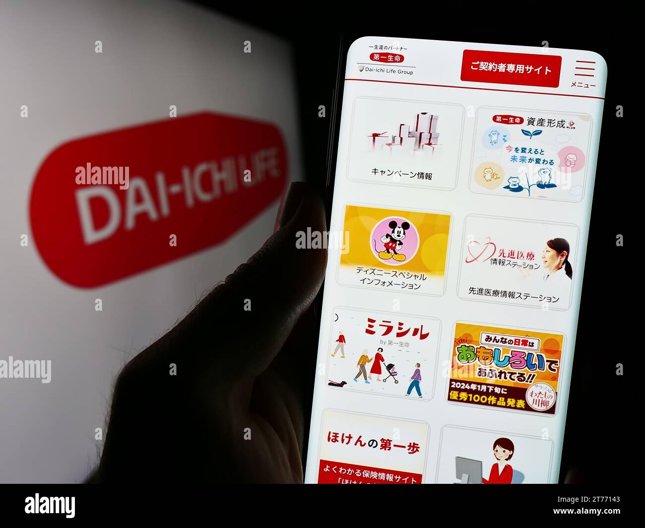 Person mit Mobiltelefon mit Website des japanischen Unternehmens Dai-ichi Life Insurance Company Limited mit Logo. Konzentrieren Sie sich auf die Mitte des Telefondisplays. Stockfoto