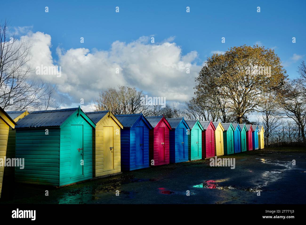 Bunte Strandhütten in einer Reihe unter blauem Himmel. Stockfoto