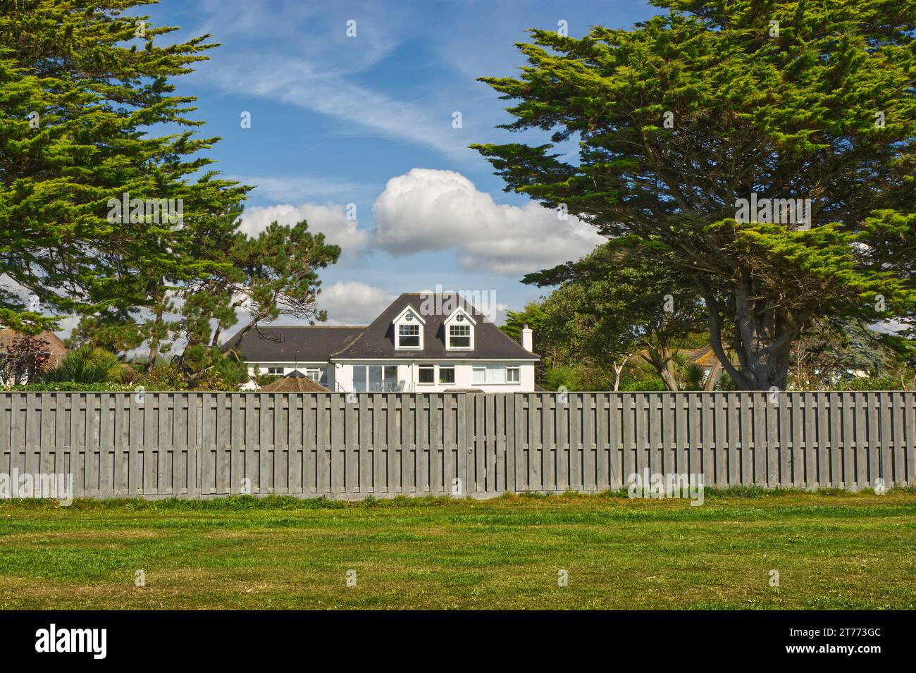 Großes Haus an der Küste in East Preston in der Nähe von Littlehampton in West Sussex, England. Blick vom Strand mit Gras und Zaun davor. Stockfoto