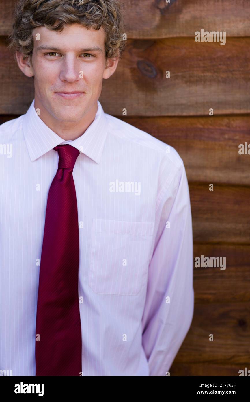 Jungunternehmer gegen eine hölzerne Wand stehend Stockfoto
