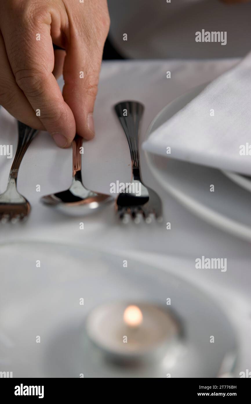 Nahaufnahme von einem Kellner Hand Anordnen von Besteck auf einen Tisch im restaurant Stockfoto